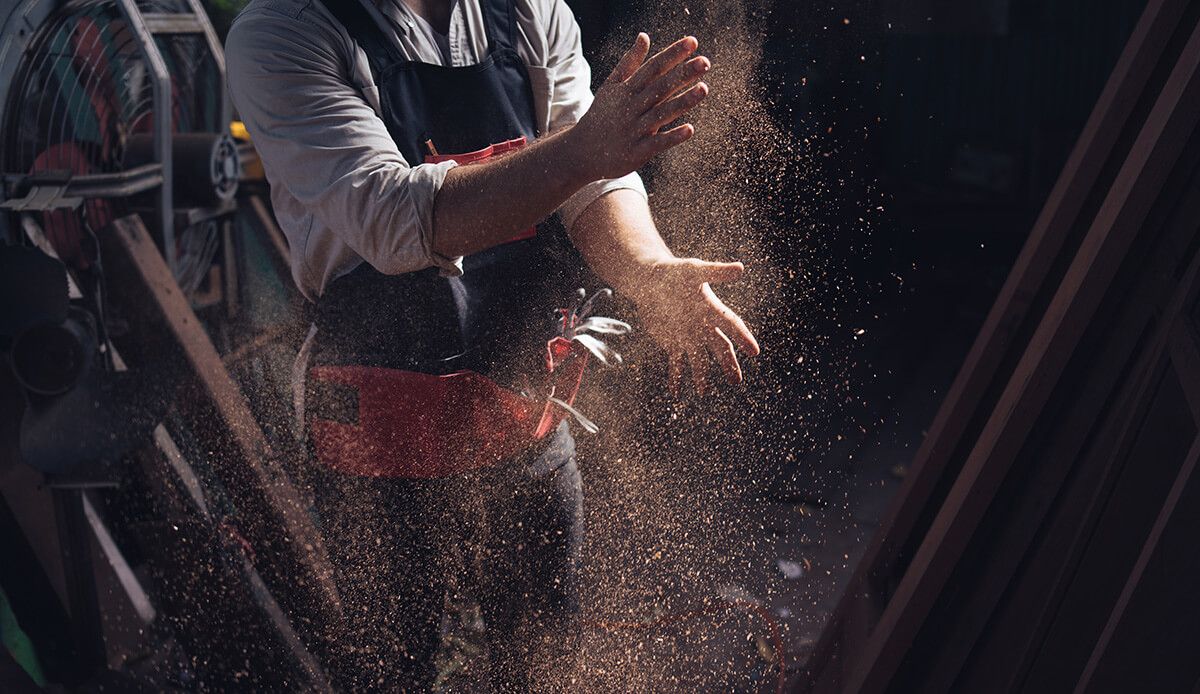 Handwerker schlägt seine staubigen Hände aus